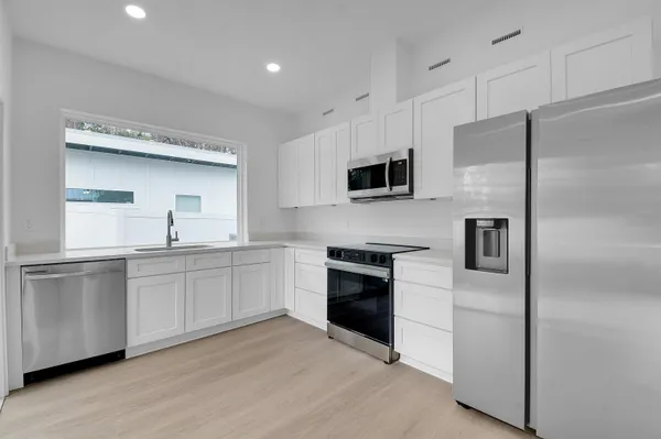 a kitchen with white cabinets and white appliances