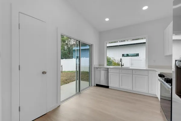 a kitchen with white cabinets and stainless steel appliances