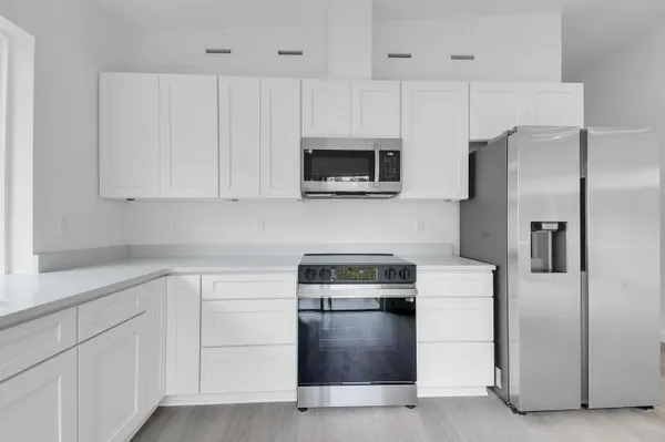 wooden floor in an empty room with a kitchen