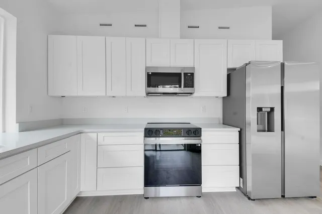 wooden floor in an empty room with a kitchen