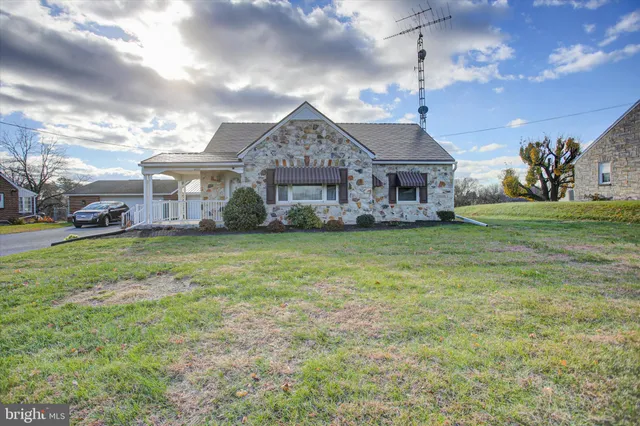 a view of a big house with a big yard and large trees