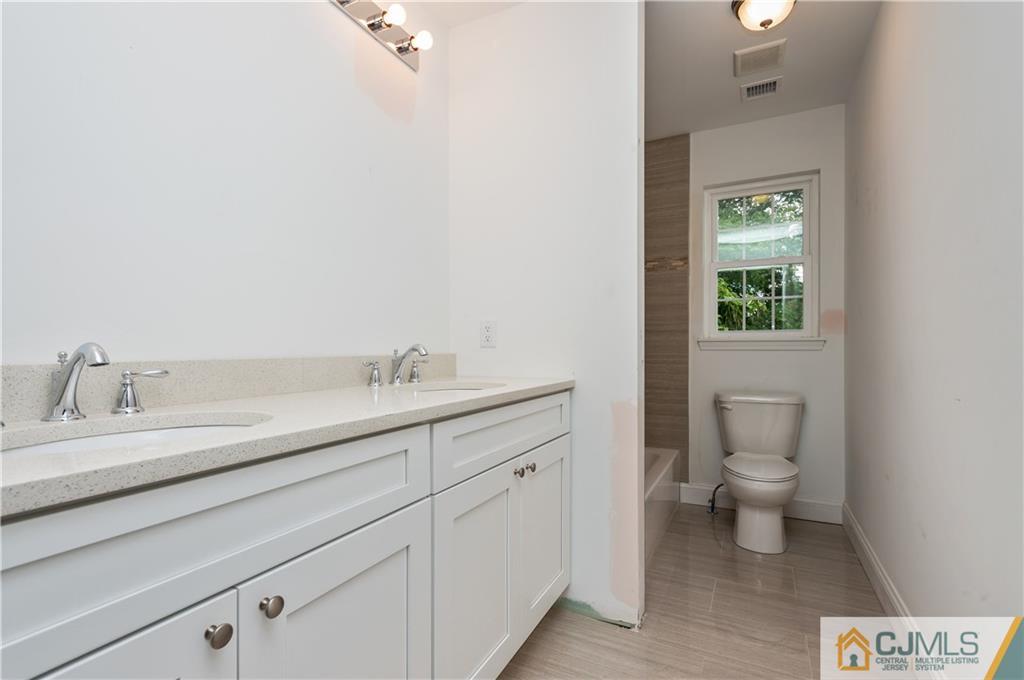 80 Ethel Road Edison, NJ 08817 - Photo 16 of 18 a spacious bathroom with a toilet sink and mirror