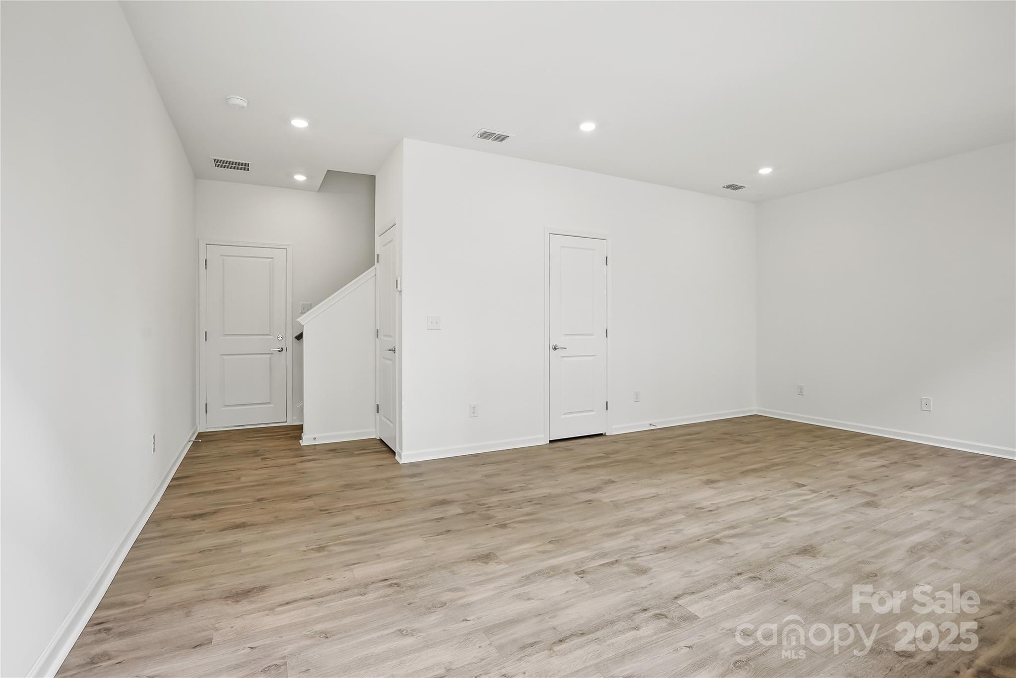 5007 Rill Court, Unit 35 Charlotte, NC 28262 - Photo 2 of 34 an empty room with wooden floor and white doors