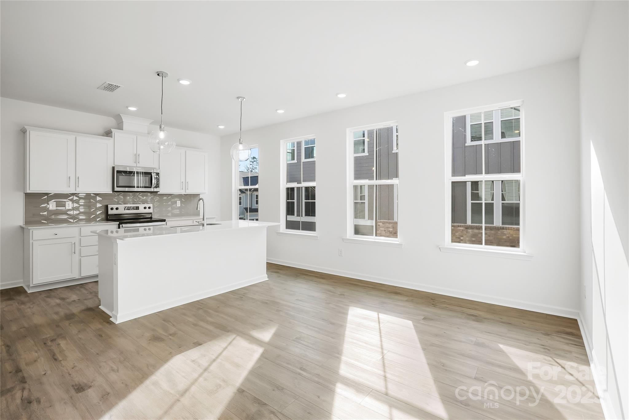 5007 Rill Court, Unit 35 Charlotte, NC 28262 - Photo 3 of 34 a kitchen with granite countertop white cabinets and stainless steel appliances