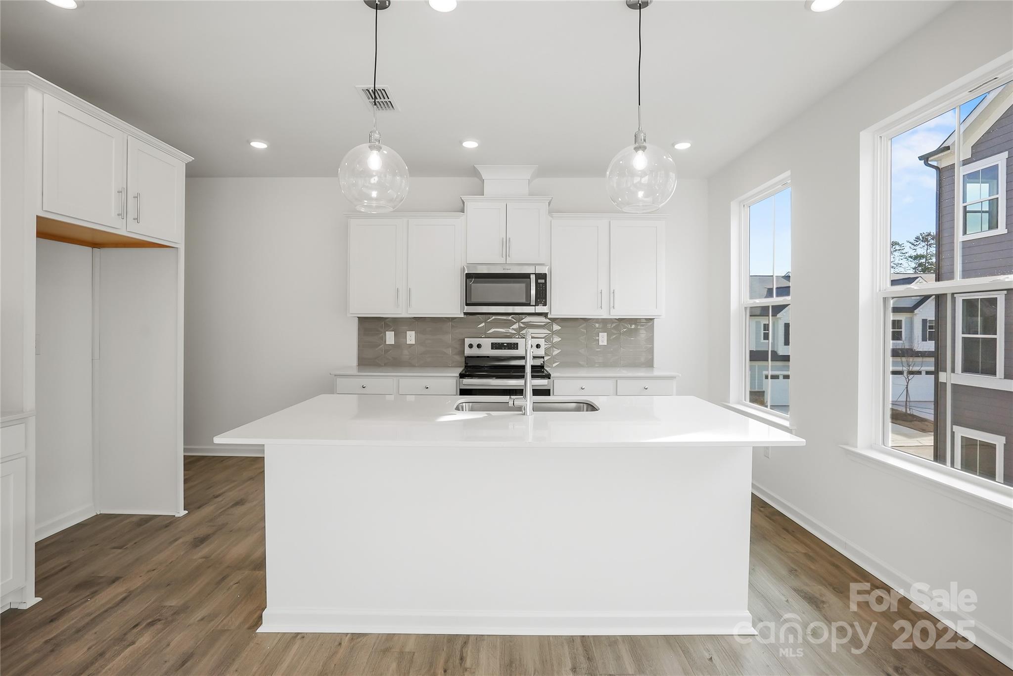 5007 Rill Court, Unit 35 Charlotte, NC 28262 - Photo 5 of 34 a kitchen with kitchen island a stove a sink a center island and a window