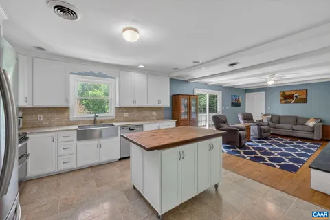 a kitchen with a stove a sink a counter top space and cabinets