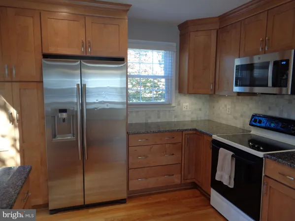 a kitchen with stainless steel appliances granite countertop a refrigerator and a stove top oven
