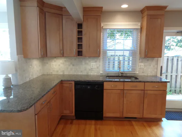 a kitchen with stainless steel appliances granite countertop wooden cabinets a sink and dishwasher