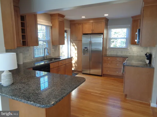 a kitchen with stainless steel appliances granite countertop a sink a stove and a refrigerator