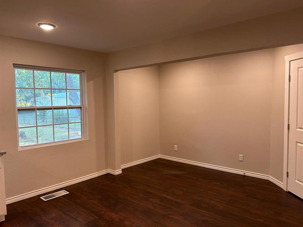 112 Elm Street Roxton, TX 75477 - Photo 4 of 21 an empty room with wooden floor and windows