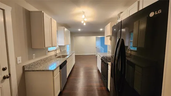 a bathroom with a granite countertop double vanity and a shower