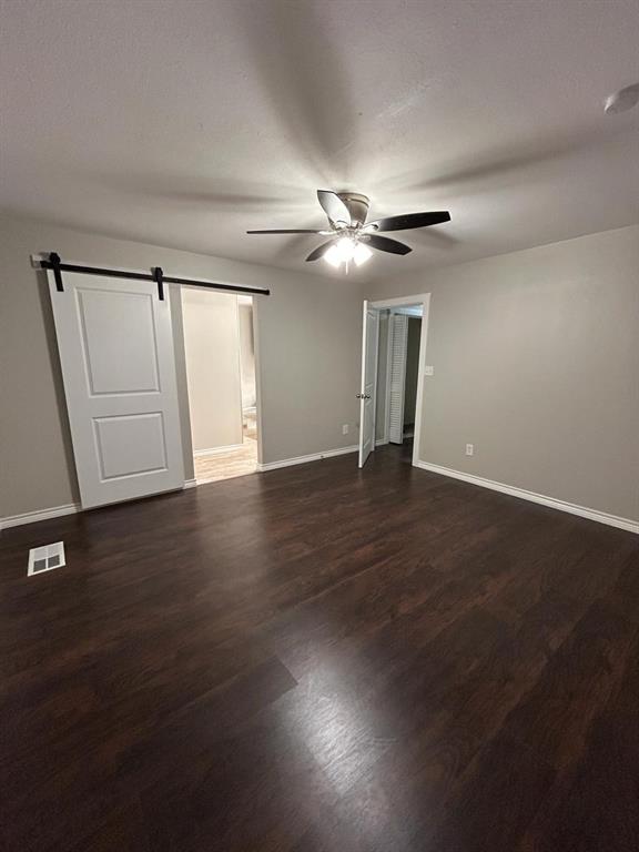 112 Elm Street Roxton, TX 75477 - Photo 10 of 21 an empty room with wooden floor chandelier fan and windows