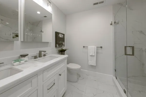 a bathroom with a toilet sink and mirror