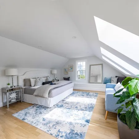 a spacious bedroom with a bed a couch and potted plant