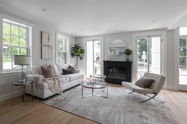 a living room with furniture a large window and a fireplace