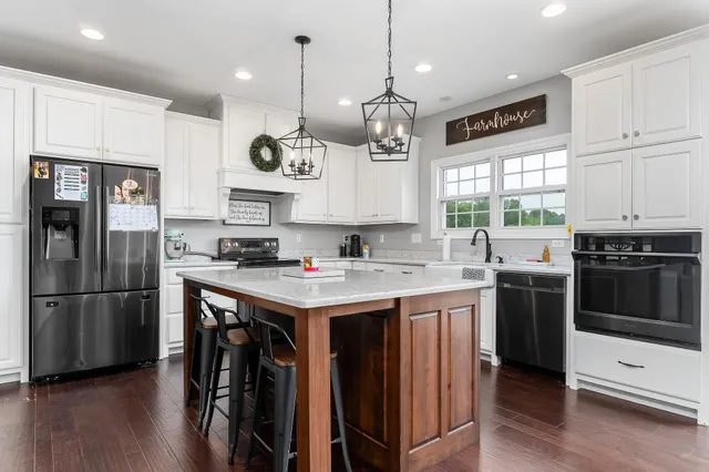 a kitchen with a refrigerator a sink and wooden floor