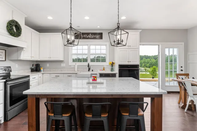 a kitchen with stainless steel appliances a table chairs refrigerator and microwave