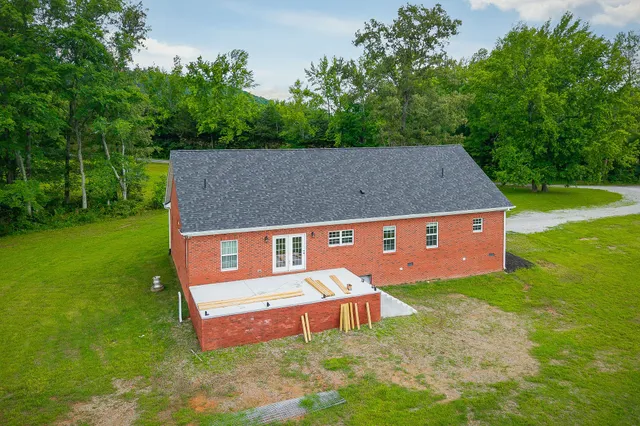an aerial view of a house with backyard and a garden