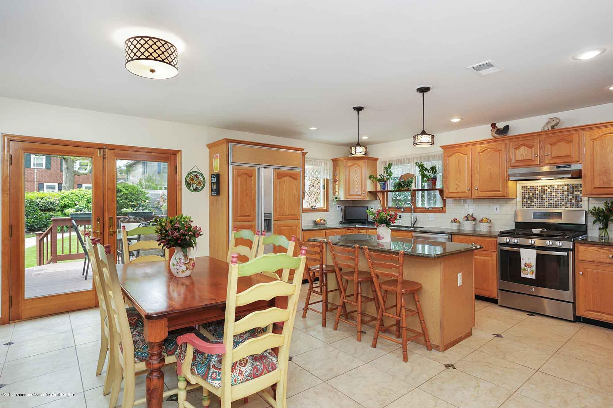 40 Ave Of Two Rivers Rumson, NJ 07760 - Photo 5 of 41 a kitchen with stainless steel appliances granite countertop a stove a refrigerator a dining table and chairs with a large window
