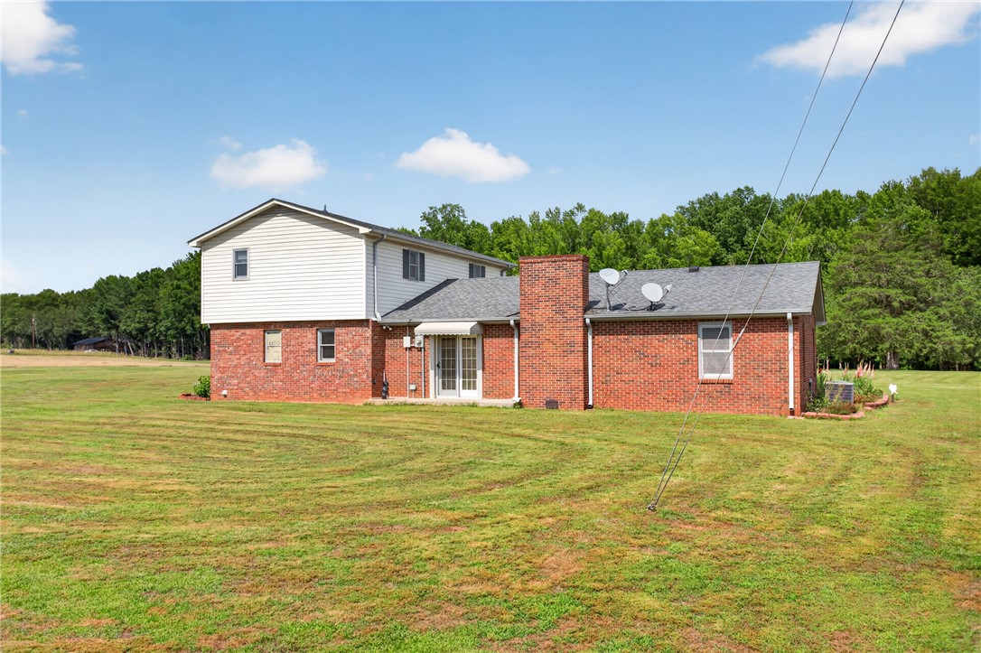 145 State Rd S-4-935 Pendleton, SC 29670 - Photo 27 of 47 A spacious yard surrounds this two-story home, featuring brick and siding construction with a classic chimney.