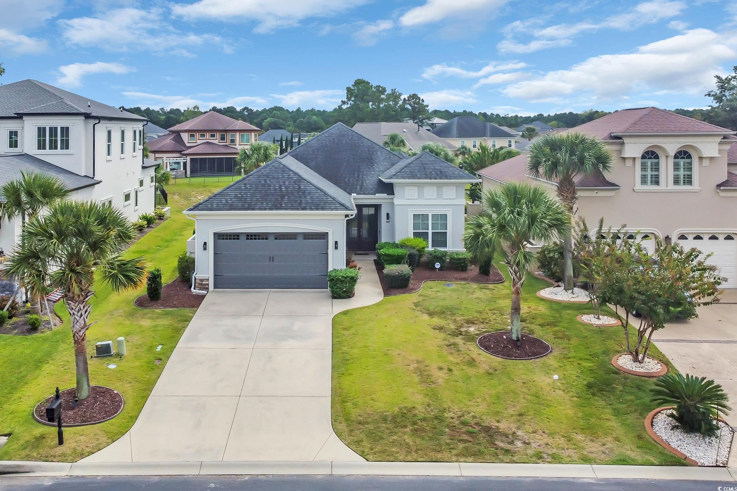 937 Bluffview Drive Myrtle Beach, SC 29579 - Photo 1 of 40 View of front facade featuring stucco siding, driveway, an attached garage, a shingled roof, and a front lawn