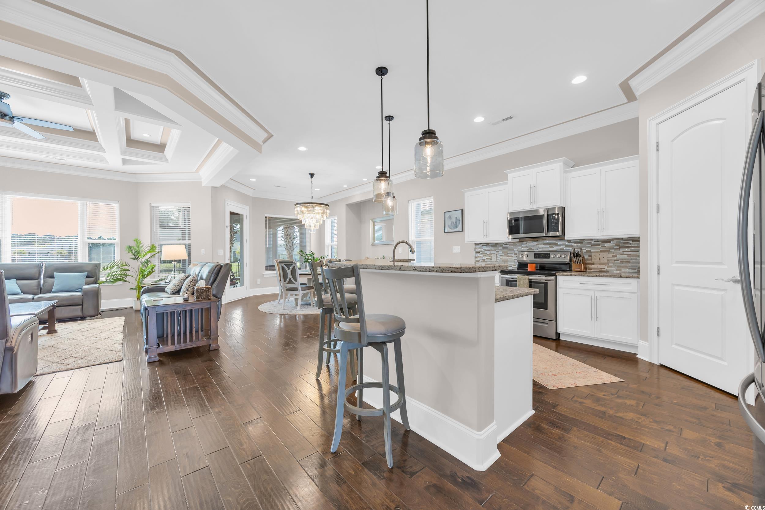 937 Bluffview Drive Myrtle Beach, SC 29579 - Photo 40 of 40 Kitchen featuring crown molding, white cabinets, a breakfast bar, pendant lighting, and open floor plan