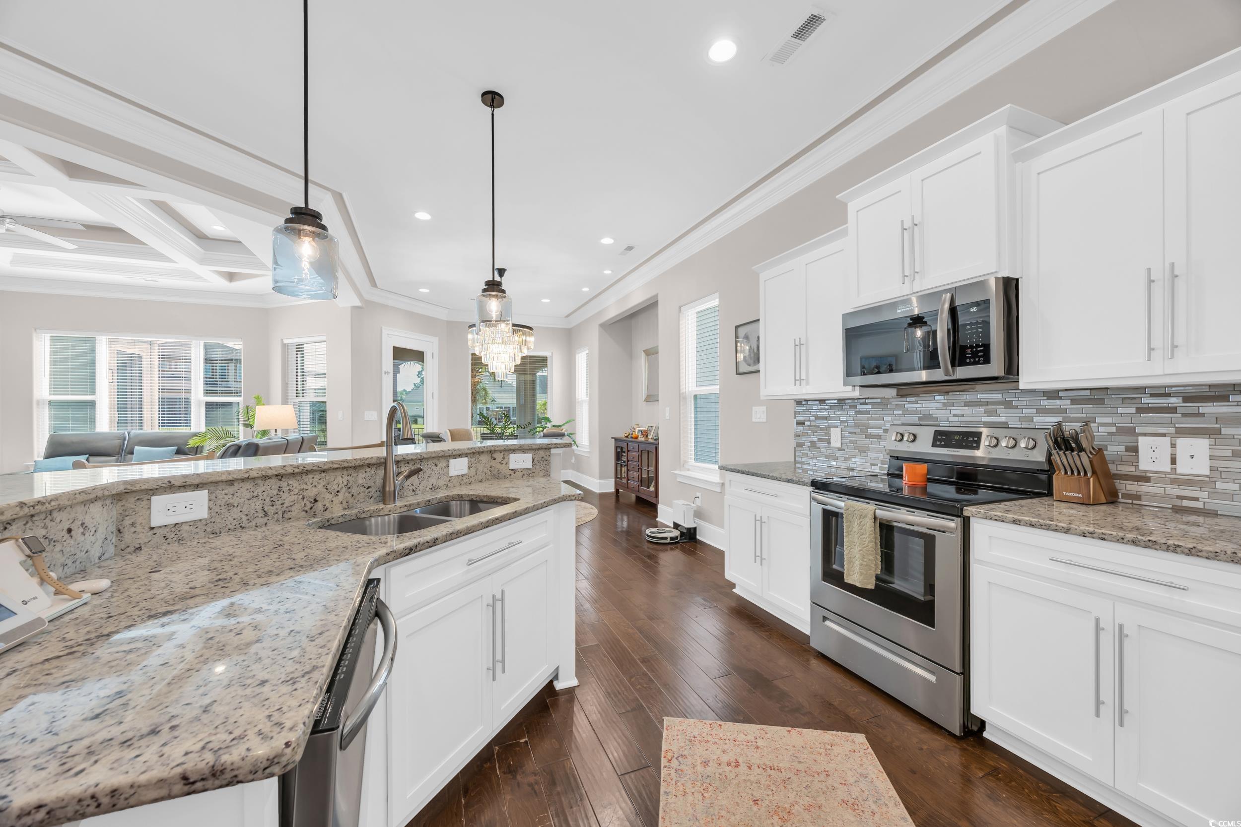 937 Bluffview Drive Myrtle Beach, SC 29579 - Photo 16 of 40 Kitchen featuring ornamental molding, appliances with stainless steel finishes, white cabinets, pendant lighting, and light stone counters