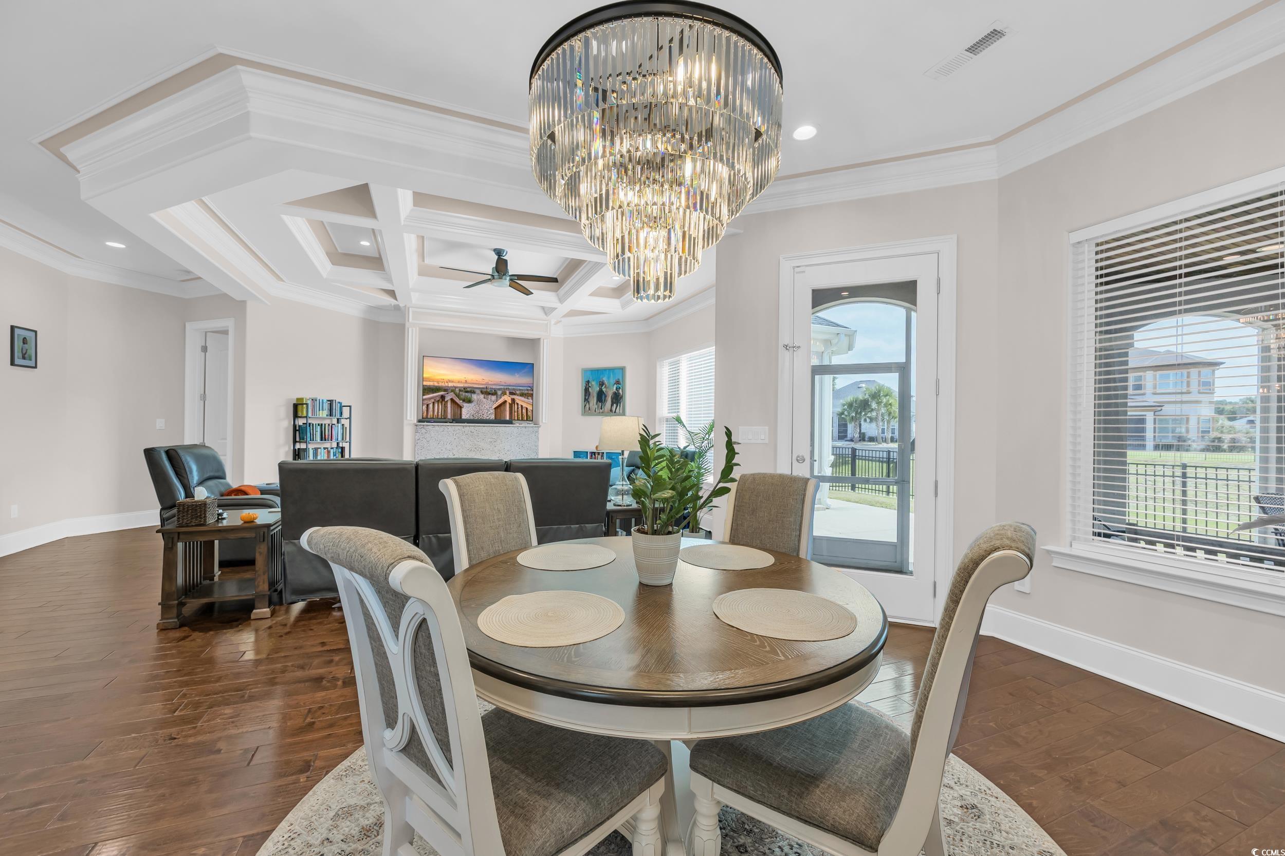937 Bluffview Drive Myrtle Beach, SC 29579 - Photo 2 of 40 Dining room featuring a chandelier, coffered ceiling, ornamental molding, beam ceiling, and dark wood-type flooring