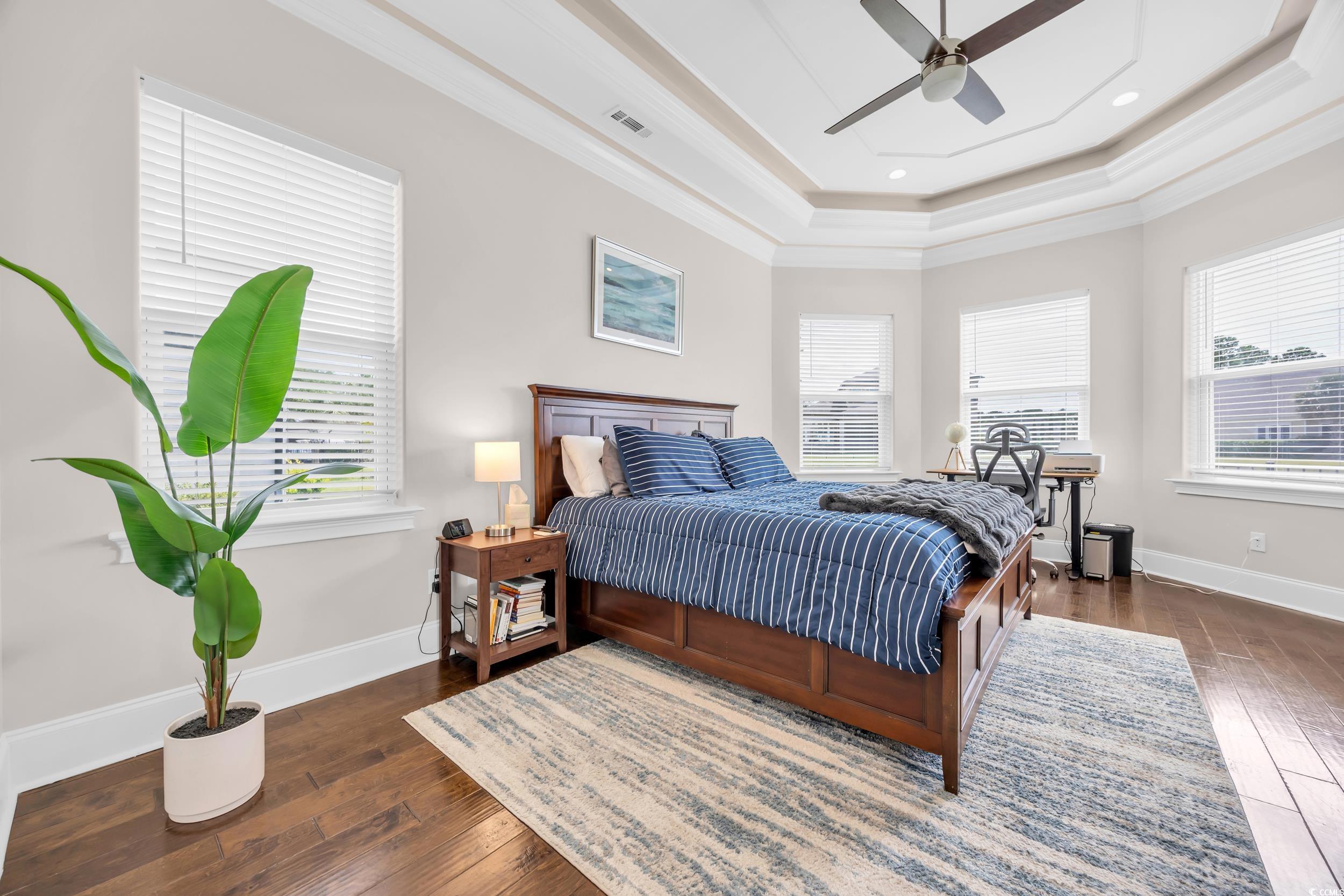 937 Bluffview Drive Myrtle Beach, SC 29579 - Photo 25 of 40 Bedroom with multiple windows, dark wood-style flooring, a raised ceiling, ornamental molding, and recessed lighting