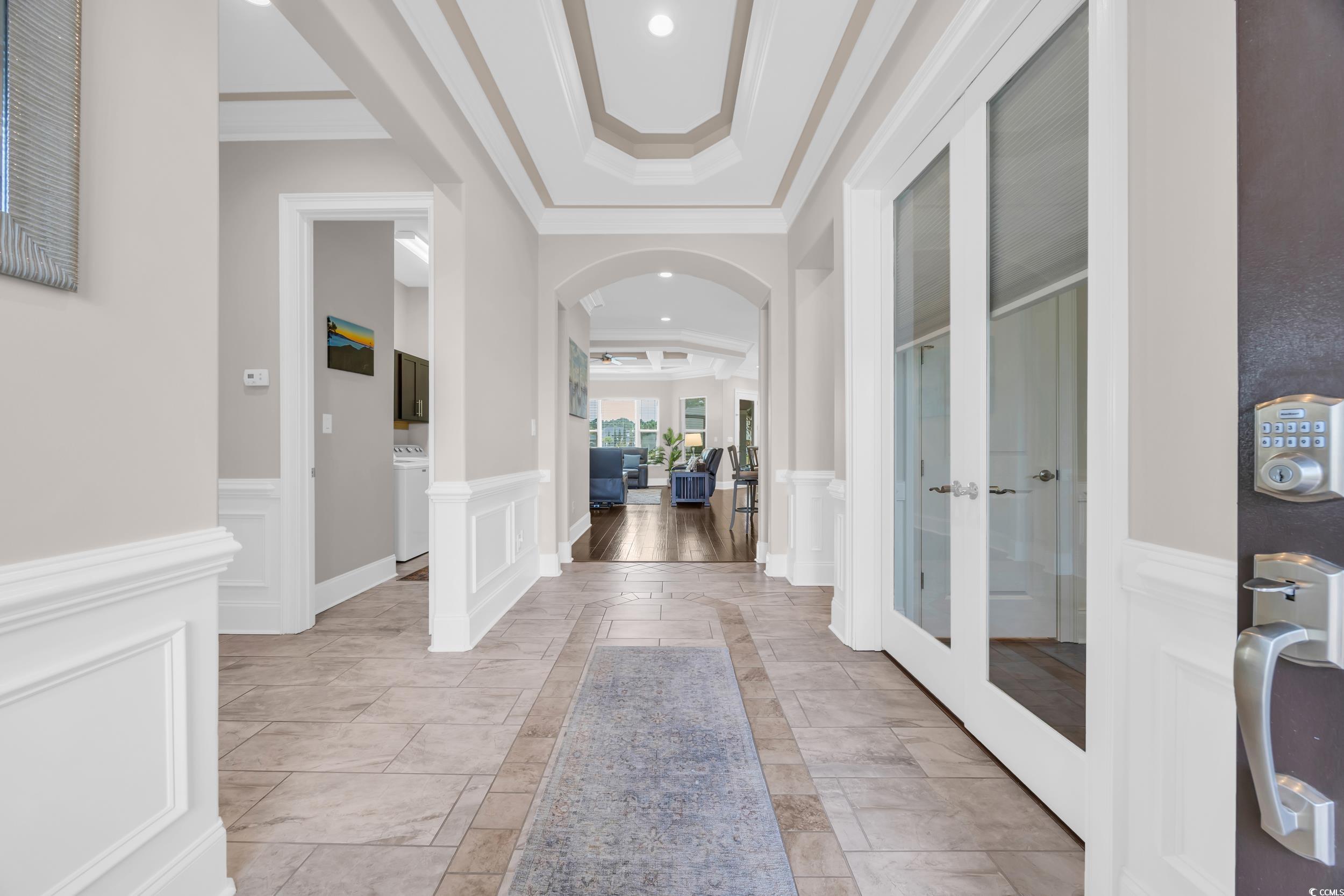 937 Bluffview Drive Myrtle Beach, SC 29579 - Photo 38 of 40 Entryway with a tray ceiling, arched walkways, a wainscoted wall, ornamental molding, and a decorative wall