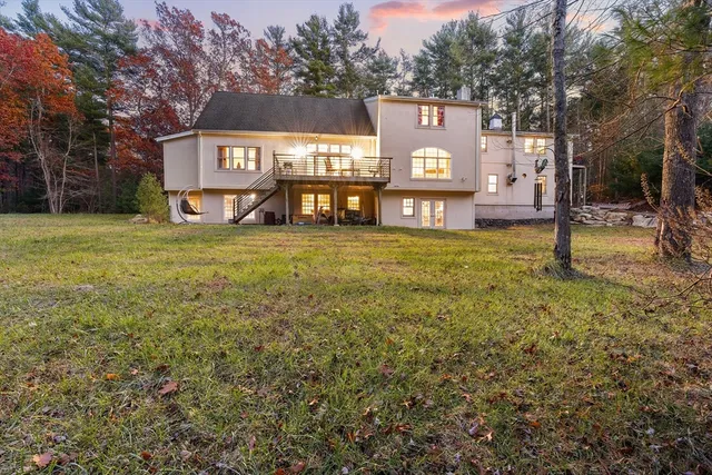 a view of a building with a yard and parking space