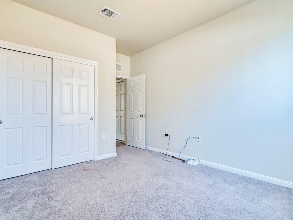 4210 Birdwatch Loop, Unit 2 Pflugerville, TX 78660 - Photo 19 of 31 A well-lit bedroom featuring soft carpet and ample closet space.