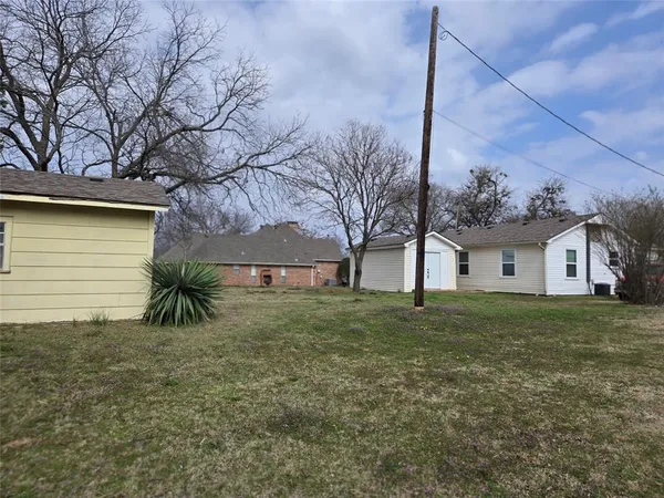 a view of a house with a large tree and a yard