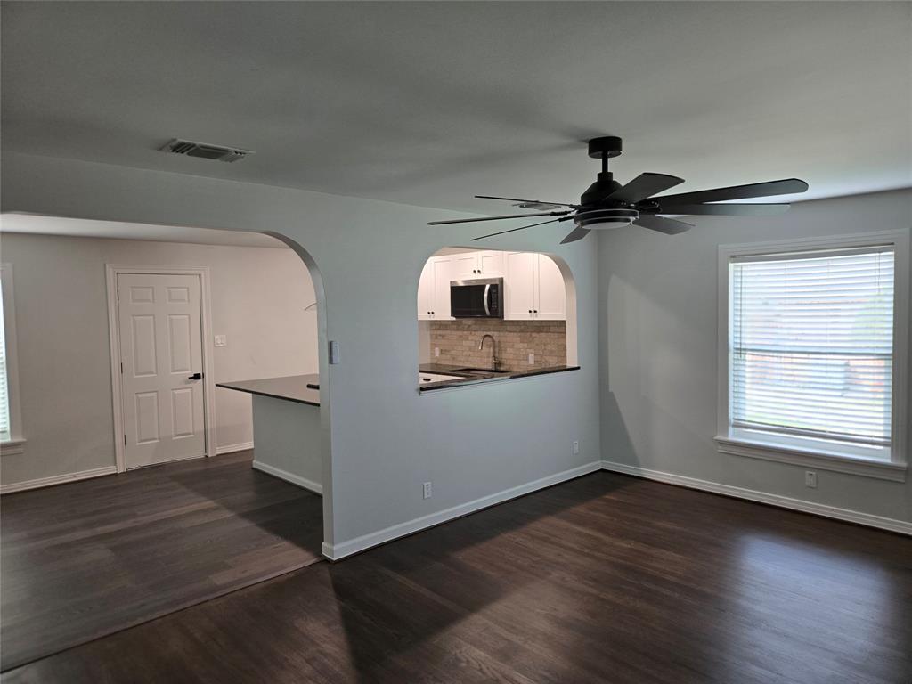 404 South Pecan Street Bells, TX 75414 - Photo 7 of 20 a view of a livingroom with wooden floor a ceiling fan and windows