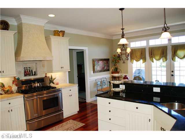 5624 Cape Fox Drive Oak Ridge, NC 27310 - Photo 5 of 16 Kitchen. Old European styled cabinetry, granite counter tops, stainless steel appliances, decorative tiled backsplash & gas stove make this a fabulous kitchen.