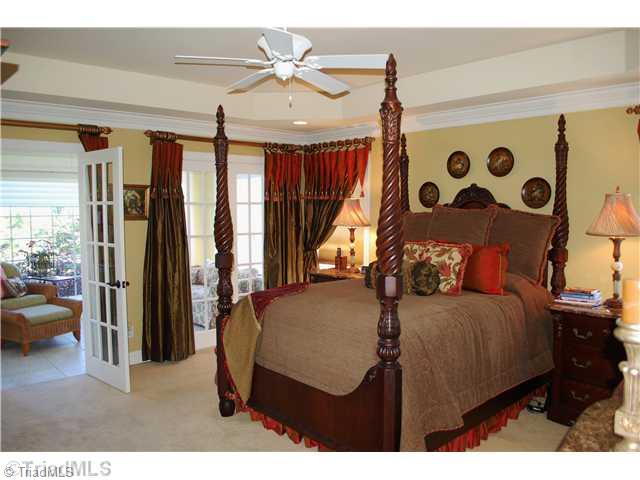 5624 Cape Fox Drive Oak Ridge, NC 27310 - Photo 8 of 16 Master Bedroom. Main level master suite features a tray ceiling, fan, large windows & French doors leading to a private sun room.