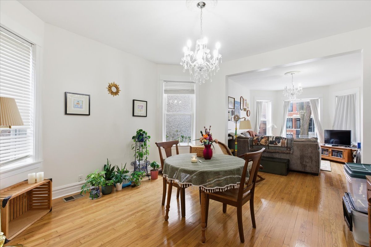 2333 North Hamlin Avenue, Unit 1 Chicago, IL 60647 - Photo 3 of 13 a view of a dining room with furniture wooden floor and chandelier