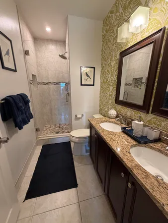 a bathroom with a granite countertop sink a mirror and a bathtub