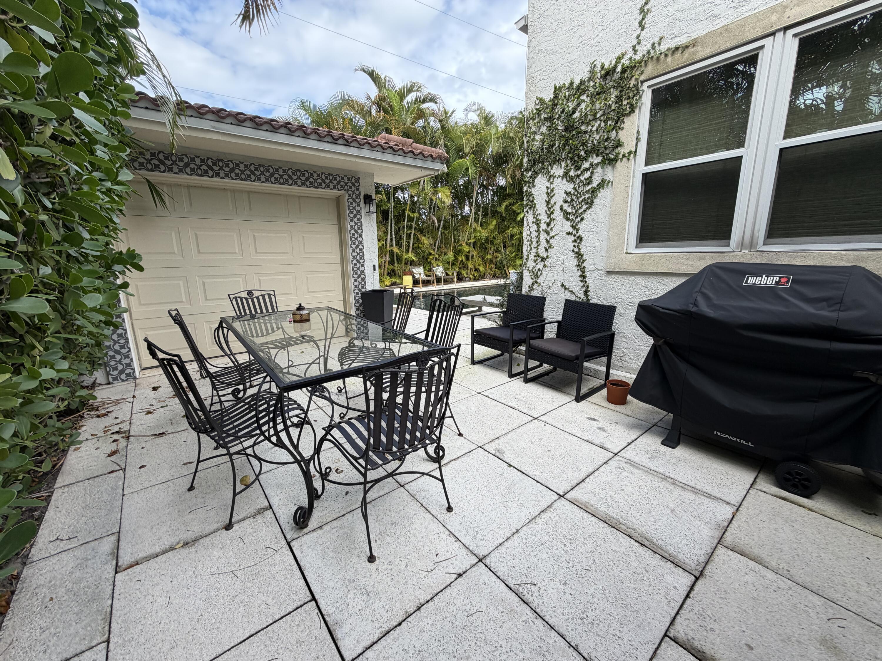 515 Ardmore Road West Palm Beach, FL 33401 - Photo 31 of 36 a view of a patio with table and chairs with wooden floor and fence