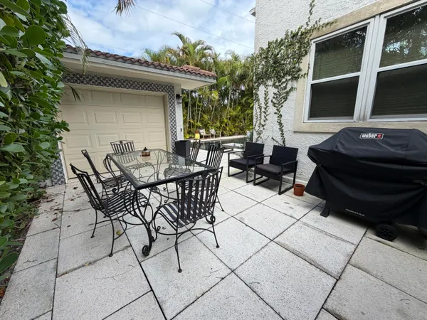 a view of a patio with table and chairs with wooden floor and fence
