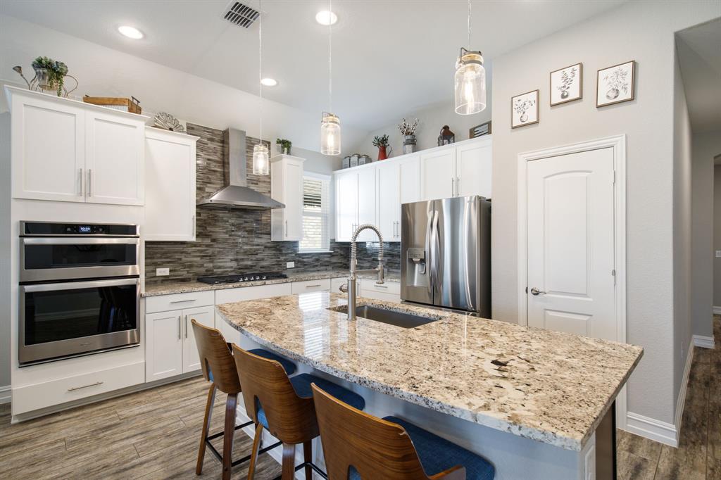 4113 Crossroads Court Oak Point, TX 75068 - Photo 7 of 33 a kitchen with stainless steel appliances granite countertop a table chairs stove and refrigerator