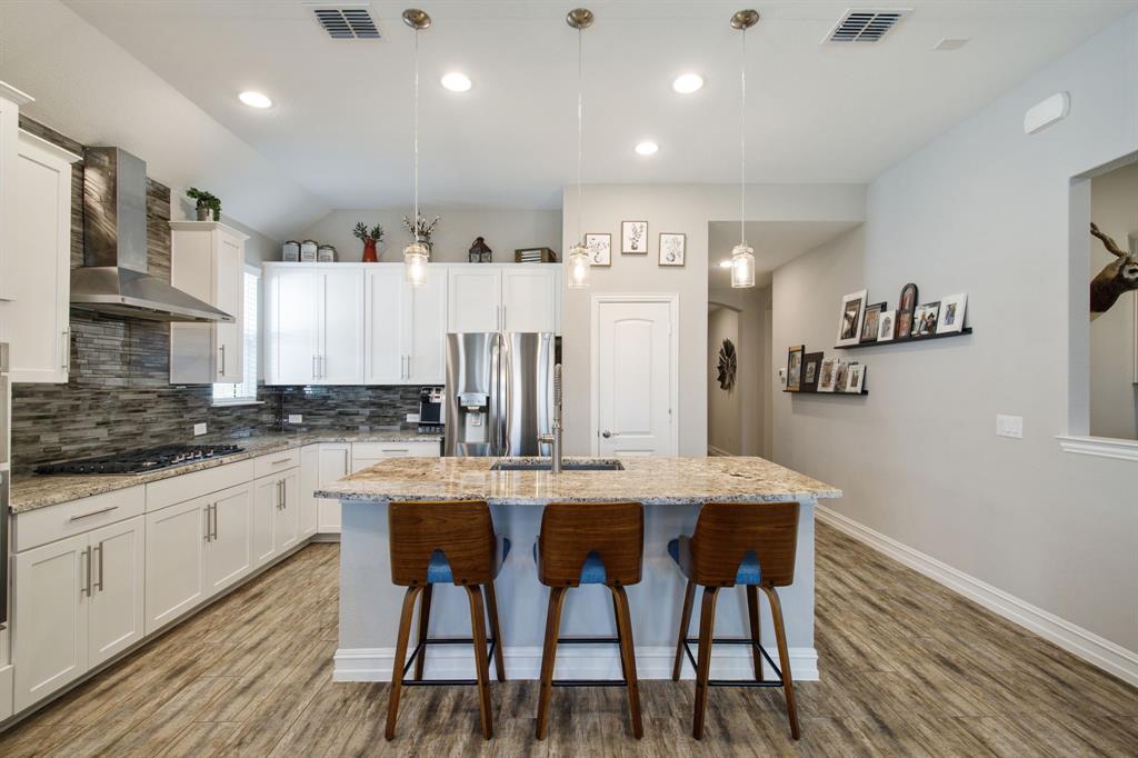 4113 Crossroads Court Oak Point, TX 75068 - Photo 9 of 33 a kitchen with stainless steel appliances granite countertop a table chairs sink and cabinets