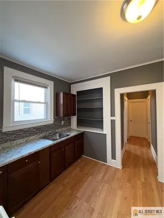 a kitchen with granite countertop a sink and cabinets