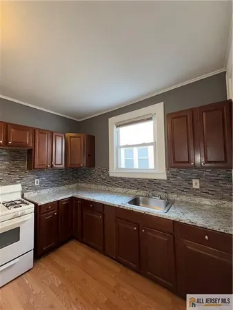 a kitchen with stainless steel appliances granite countertop a sink stove and cabinets