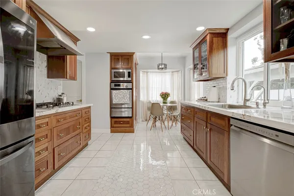 a kitchen with stainless steel appliances granite countertop a sink and a refrigerator