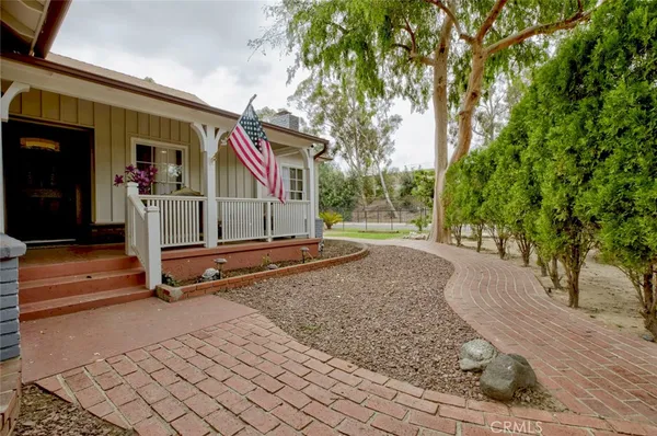 a view of backyard with large trees and wooden fence
