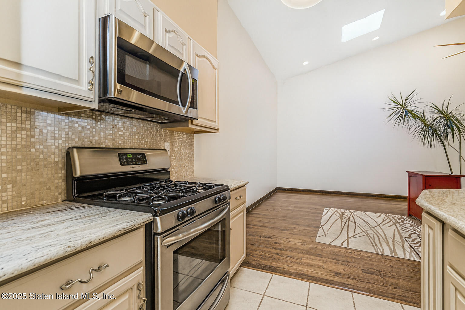 175 Winding Woods Loop, Unit 69 Staten Island, NY 10307 - Photo 15 of 29 a kitchen with granite countertop a stove top oven a sink dishwasher and cabinets with wooden floor
