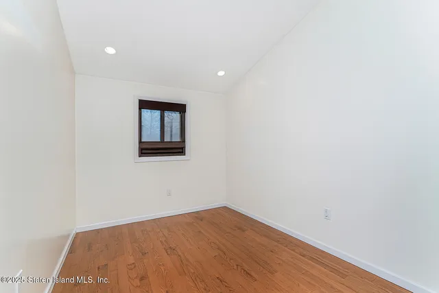 a view of a hallway with wooden floor and entryway