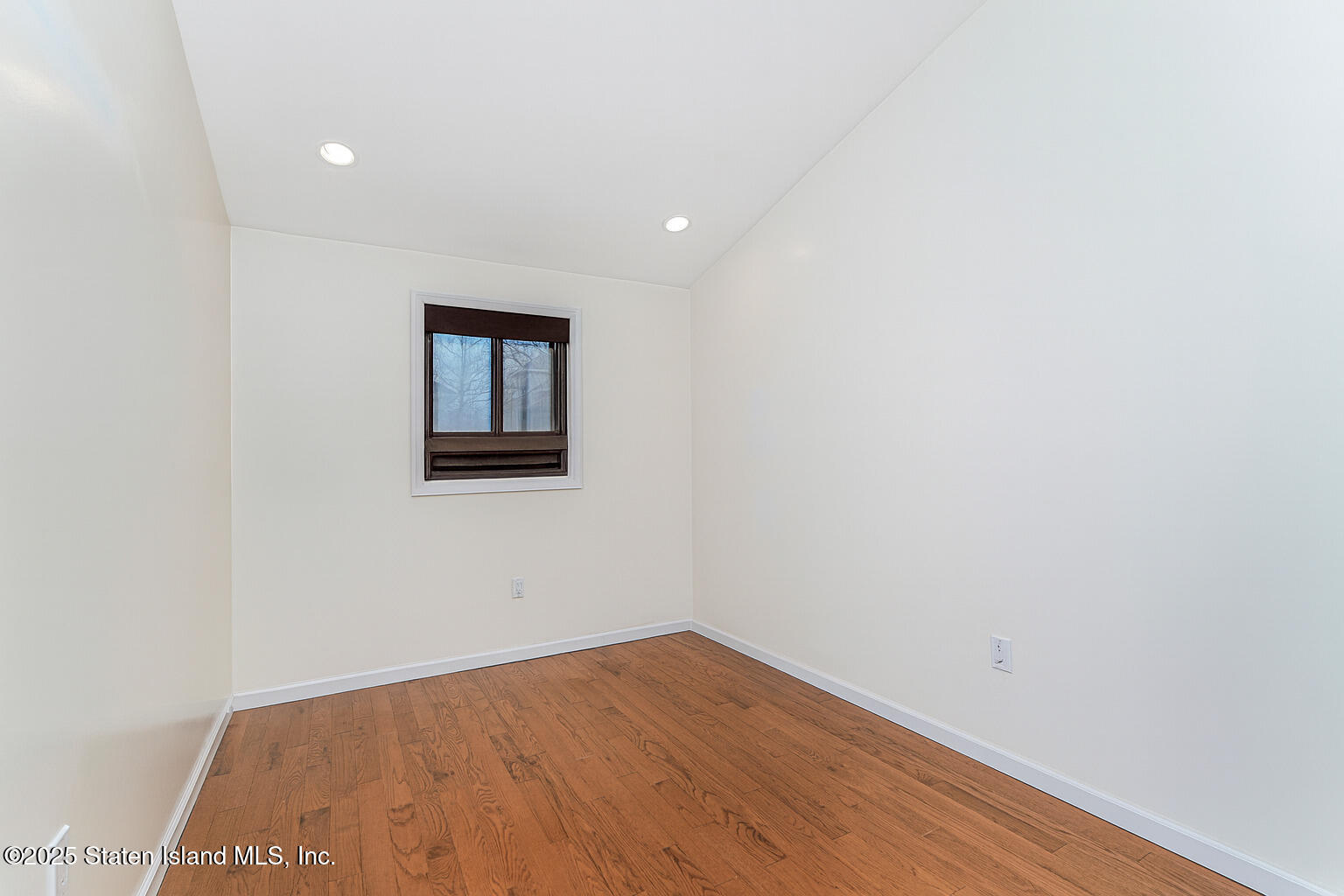 175 Winding Woods Loop, Unit 69 Staten Island, NY 10307 - Photo 19 of 29 a view of an empty room with wooden floor and a window