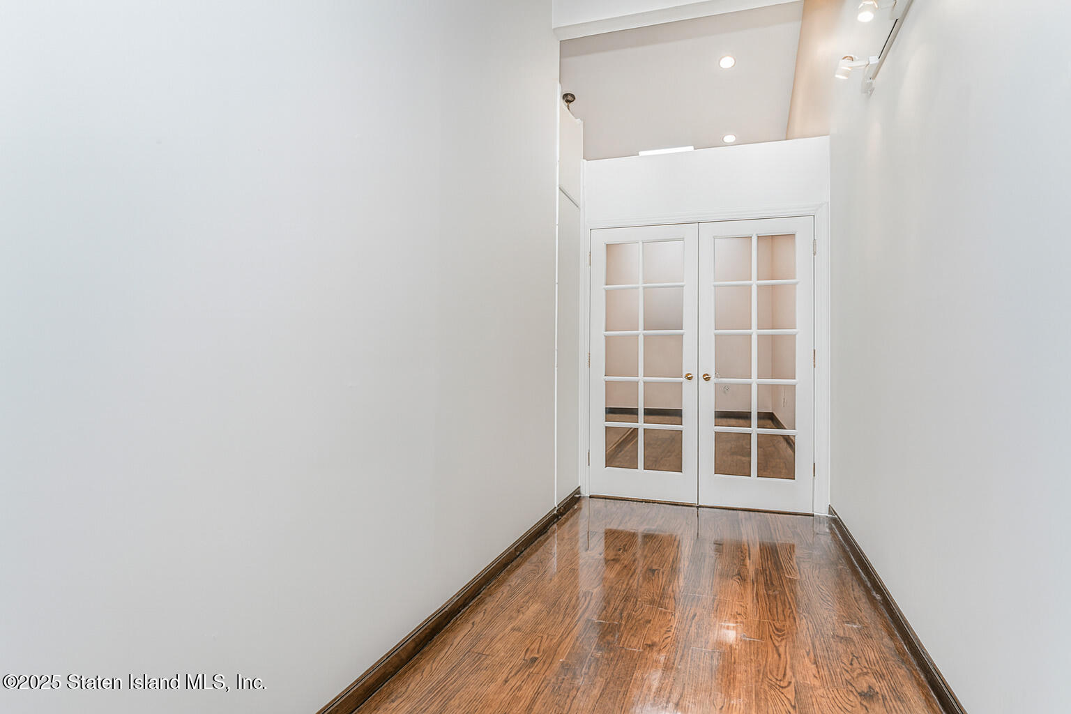 175 Winding Woods Loop, Unit 69 Staten Island, NY 10307 - Photo 21 of 29 a view of an empty room with wooden floor and a window